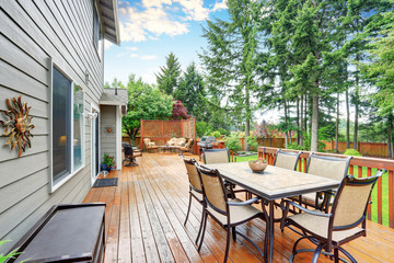 Spacious wooden deck with patio area and attached pergola.