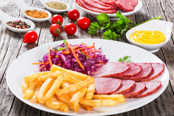 french fries and sliced smoked meat with cabbage salad