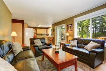 Cozy living room with leather sofas and brick fireplace.