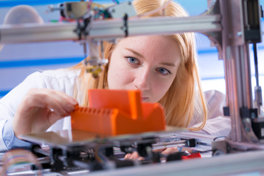 Young woman work with 3d printer