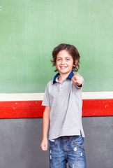 Elementary schoolboy pointing finger toward camera