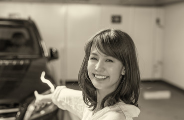 Obraz na płótnie Canvas Happy japanese girl showing her brand new car