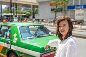 Happy japanese girl looking for taxi in Tokyo