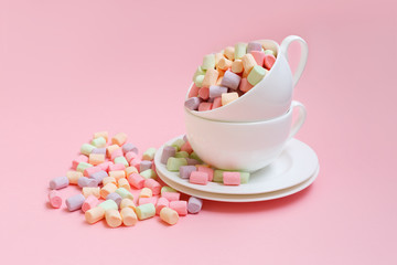 Fototapeta na wymiar Pastel colored marshmallow in a cup on a pink background. Sweet unhealthy food. 