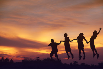 Fototapeta premium Stock Photo:.Silhouette the boy jumping over sunset