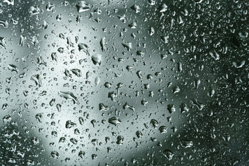 Fototapety  krople deszczu na szybie okiennej z tłem przyrody