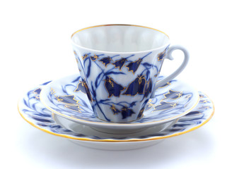 Porcelain cup, plate and saucer on a white background