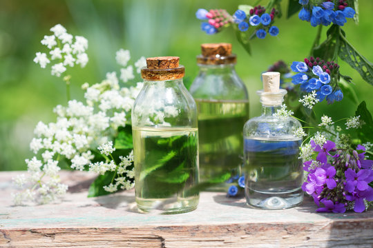 Essential aroma oil  in bottles on wooden background outdoor.