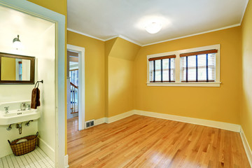 Empty room interior in yellow tones and hardwood floor.