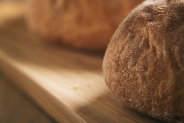 freshly baked ciabatta cut in half on olive board