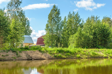 Obraz premium The house on the shore of a forest river