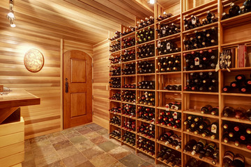 Bright home wine cellar with wooden storage units with bottles. - 118604925