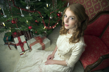 Viktorianisch anmutende Weihnachtsszene mit junger rothaarigen Frau in einem historischen Kleid