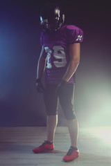 American football player on smoky background