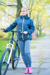 Fototapeta na wymiar Young woman with bike in park