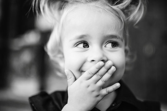 Black And White Picture Of Pretty Girl Hiding Her Smile Behind T