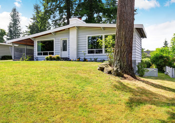 Fototapeta na wymiar One level house with siding trim and well kept lawn
