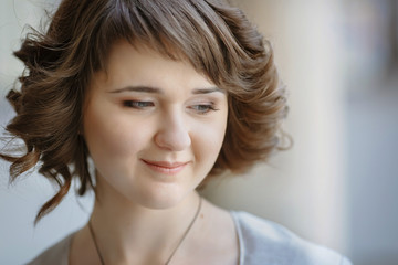 Naklejka premium Portrait of pretty curly lady looking down thoughtful