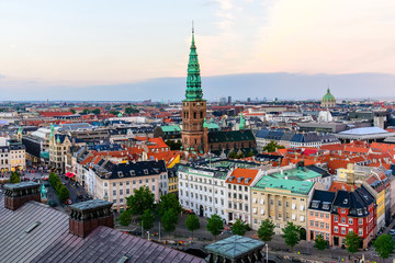 Fototapeta na wymiar Copenhagen skyline by evening. Denmark capital city streets and danish house roofs. Copenhagen old town and copper spiel of Nikolaj Church panoramic view from top of Christiansborg palace.