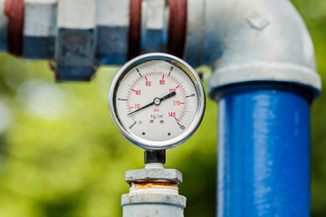 Water pressure meter installed on a blue pipe