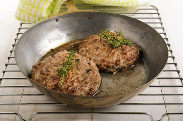 hungarian mangalica burger with thyme in a brass pan