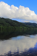 Fototapeta premium 湖に反射する青空と低い山々と積乱雲