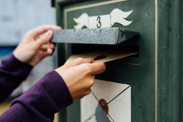 Posting letter to old postbox on street