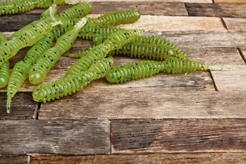 Fishing jig baits on wooden background. Macro shot.