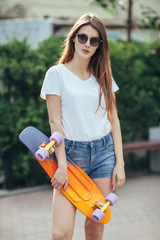 Sport fashion brunette girl in denim shorts, posing in summer wi