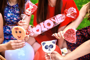 Young women hold candies in their hands