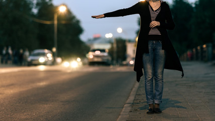 young woman tries to catch car on night road