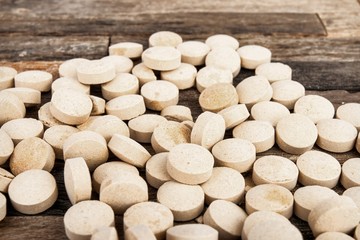 Medicine pills on wooden background. Stock image macro.