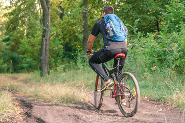 Fototapeta na wymiar Mountainbiker riding on bicycle in summer park at sunny day.