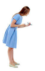 back view of writing beautiful woman. Rear view people collection.  backside view of person. Isolated over white background. Skinny girl in a blue dress draws a felt-tip pen. side view