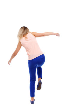 Balancing young woman. or dodge falling woman. Rear view people collection.  backside view of person. Isolated over white background. The blonde in a  pink shirt standing on one leg. Stock Photo