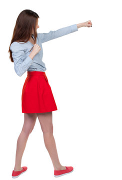 skinny woman funny fights waving his arms and legs. Isolated over white background. Long-haired brunette is cancer and has boxed in a red skirt