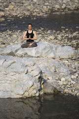 Amazing beautiful girl does yoga near the river.