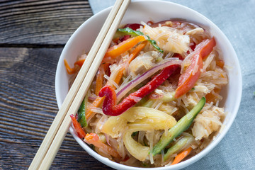Rise noodles in white bowl on wooden background