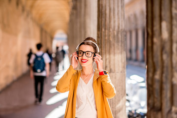 Portrait of a young female student dressed casually in the famous arched galleries in Bologna city in Italy. Bologna is student city and home to the oldest university in the world © rh2010