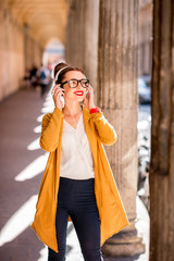 Fototapeta premium Portrait of a young female student dressed casually in the famous arched galleries in Bologna city in Italy. Bologna is student city and home to the oldest university in the world