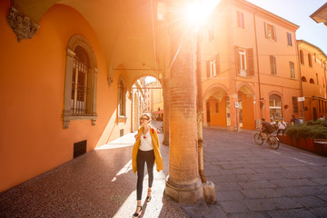 Young female student walking arched gallery on the way to university in Bologna city in Italy © rh2010