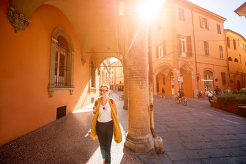 Young female student walking arched gallery on the way to university in Bologna city in Italy © rh2010