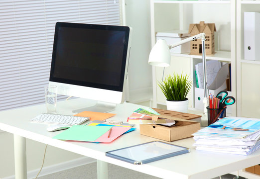 Designer working desk with computer and paperwork