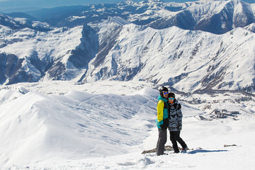 Fototapeta na wymiar Couple in love snowboarder snowboarding on fresh white snow on ski slope on Sunny winter day