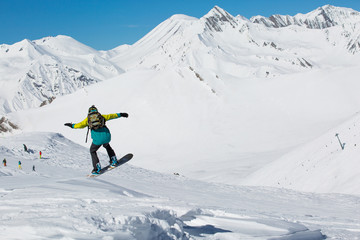 Fototapeta na wymiar Man snowboarder snowboarding on fresh white snow on ski slope on Sunny winter day