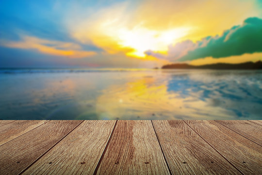 Fototapeta wooden plank at the beach with blurred of sunset time.