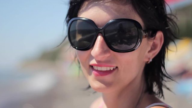 Close up portrait of beautiful young woman with sunglasses on tropical beach