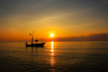 Fototapeta na wymiar Fishermen on boat in sunrise