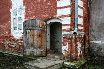 wooden medieval door in a brick wall of a monastic structure