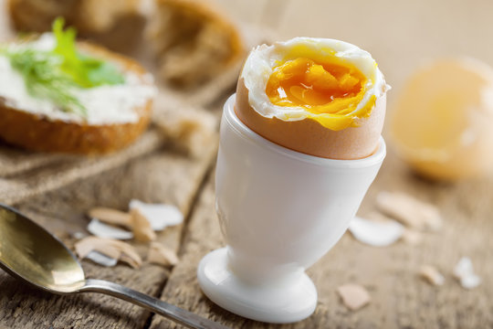 Breakfast with perfect soft boiled egg and sandwich with cheese. Traditional homemade food.